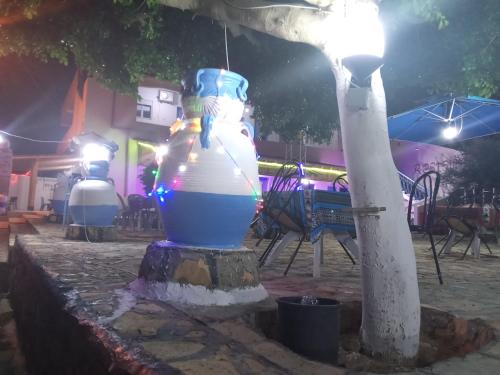 a large blue and white vase sitting next to a tree at dar fatma matmata in Matmata
