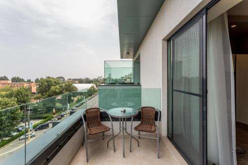 a glass balcony with a table and chairs on it at New Splendid Hotel & Spa - Adults Only (+16) in Mamaia