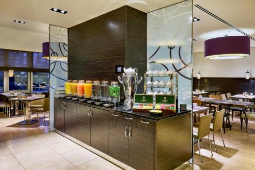 a bar in a restaurant with tables and chairs at Four Points by Sheraton Munich Arabellapark in Munich