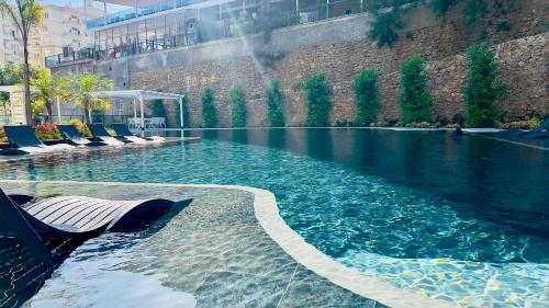a swimming pool with lounge chairs in a building at 2-х комнатная квартира в ЖК класса Luxe, Тосмур in Alanya