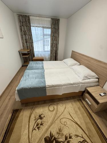 a bedroom with a large bed and a window at Florina namai in Marijampolė