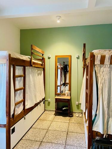 a room with two bunk beds and a mirror at Pequi hostel in Florianópolis