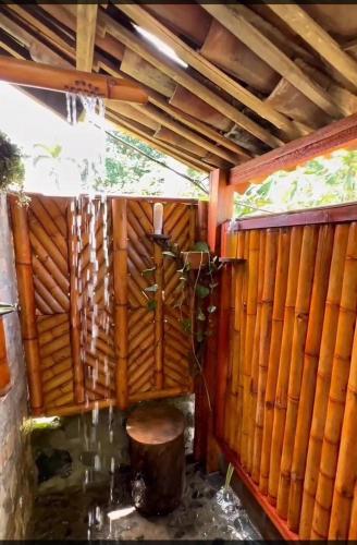 a room with a wooden wall with a table at La villa Glamping in Buga