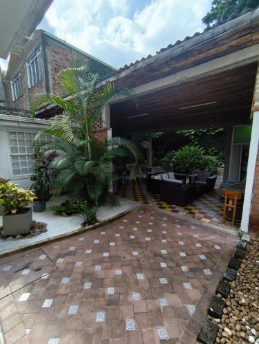 a patio of a house with a palm tree at In Situ Hotel in Cali