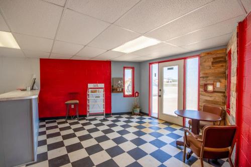 a room with a red wall and a checkered floor at OYO Crossroads Inn in Osborne