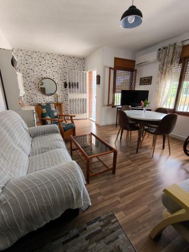 a living room with a couch and a table with chairs at El Jazmín in San Vicente del Raspeig