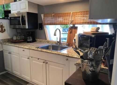 a kitchen with a sink and a stove top oven at Baycation Houseboat in Tavernier