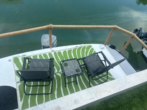 two chairs sitting on a boat in the water at Baycation Houseboat in Tavernier