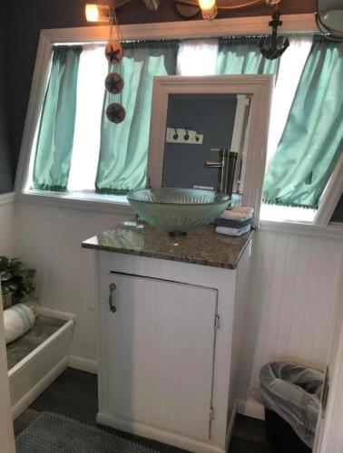 a bathroom with a bowl sink and a mirror at Baycation Houseboat in Tavernier