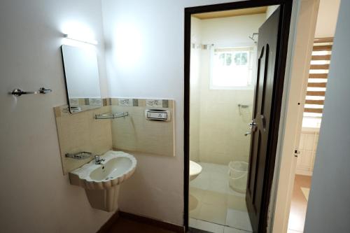 a bathroom with a sink and a toilet at The French Square in Alleppey