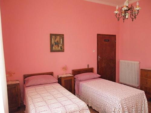 2 letti in una camera con pareti rosa di Bel Fiore a San Benedetto del Tronto
