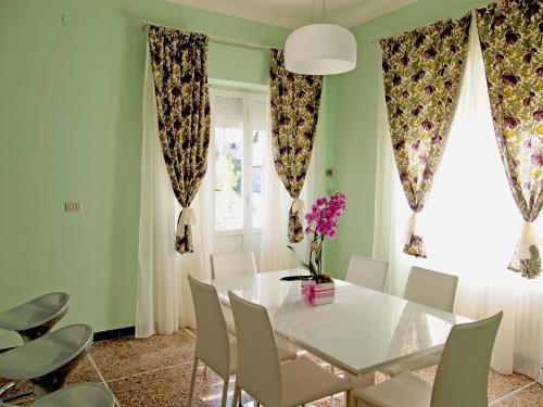 une salle à manger avec une table et des chaises blanches dans l'établissement Bel Fiore, à San Benedetto del Tronto