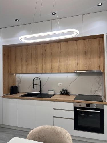 uma cozinha com pia e fogão forno superior em Arjola Cozy Stay em Korçë
