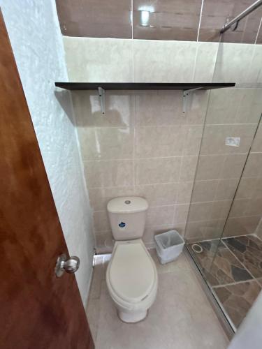a bathroom with a toilet and a glass door at La casona de la loma Ibague in Ibagué