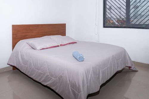 a white bed with a wooden headboard and a pillow at El susurro del agua casa blanca exclusiva natural in Ibagué