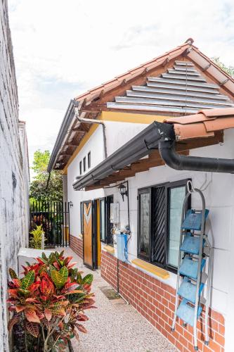a house with a blue ladder outside of it at El susurro del agua casa blanca exclusiva natural in Ibagué