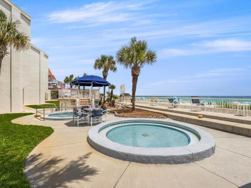 a swimming pool with a table and chairs and the ocean at Latitude 29 Condominiums #18 in Sunnyside
