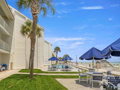a patio with tables and chairs and blue umbrellas at Latitude 29 Condominiums #18 in Sunnyside