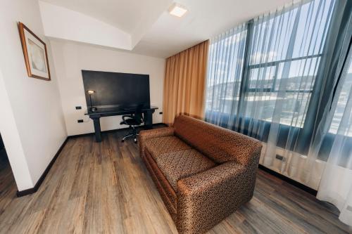 a living room with a couch and a flat screen tv at La Quinta by Wyndham Quito in Quito