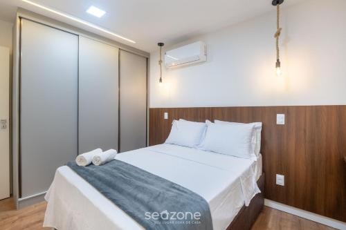 a bedroom with a large bed with white sheets and pillows at Prédio c/ Aptos Novos a 300m da Praia - EEP in Guarapari