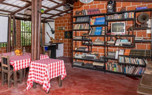 a room with two tables and a brick wall with books at El susurro del agua exclusiva - natural in Ibagué