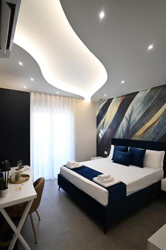 a bedroom with a large bed and a table at Plaza Rooms Luxury B&B in Pagani