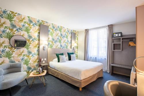 a hotel room with a bed and a chair at Best Western Hotel Saint Claude in Péronne