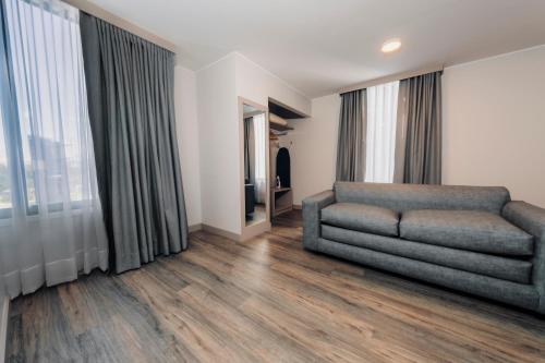 a living room with a couch and a window at La Quinta by Wyndham Quito in Quito