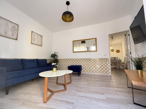 un soggiorno con un divano blu e un tavolo di Casa Algarvia a Portimão