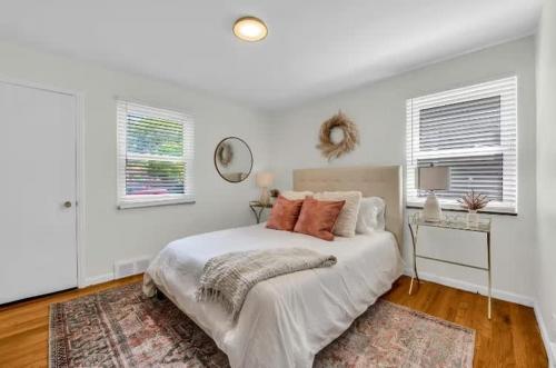 a white bedroom with a large bed and a mirror at Grosse Pointe Detroit 3BR - Sleeps 8 - Yard home in Grosse Pointe