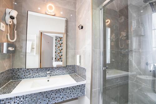 a bathroom with a sink and a shower and a mirror at Best Western Hotel Saint Claude in Péronne