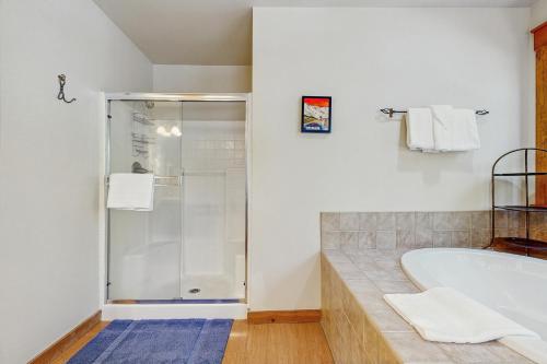 a bathroom with a tub and a glass shower at 3 Quelah in Sunriver