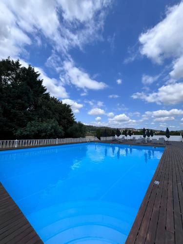 a large blue swimming pool on a wooden deck at Casas do Souto in Lousada