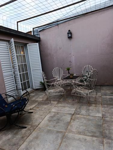 a patio with three chairs and a table at Casa costanera oeste in Posadas