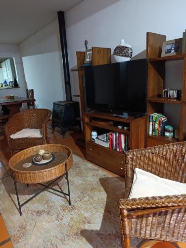 a living room with a tv and chairs and a table at Casa costanera oeste in Posadas