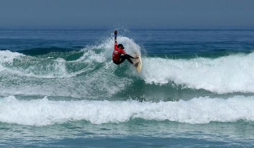 a man riding a wave on a surfboard in the ocean at L'adresse est près de la plage in Agadir