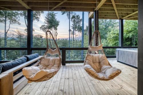 two hanging hammocks on a deck with a view at Morgan Trail - Stunning Mountain Masterpiece in Epworth