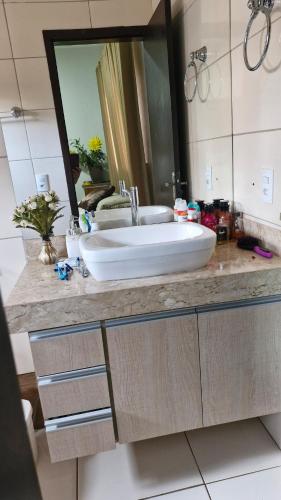 a bathroom with a sink and a large mirror at Casa Fernandes in Rio Verde