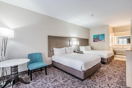 a hotel room with two beds and a table at Grand Legacy At The Park in Anaheim