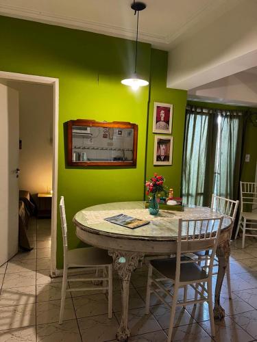a dining room with a table and a green wall at Los Lapachos in San Miguel de Tucumán