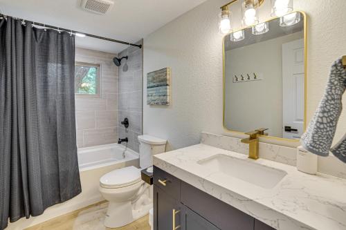 a bathroom with a sink and a toilet and a mirror at Private Dock Waterfront Cedar Creek Lake Home in Eustace