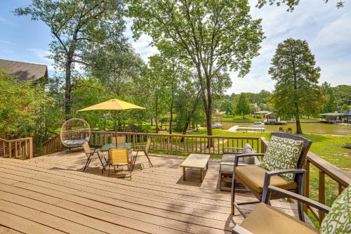 a wooden deck with chairs and an umbrella at Private Dock Waterfront Cedar Creek Lake Home in Eustace