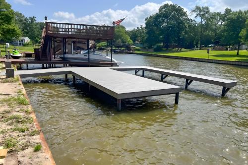 a dock in the water with a boat in it at Private Dock Waterfront Cedar Creek Lake Home in Eustace