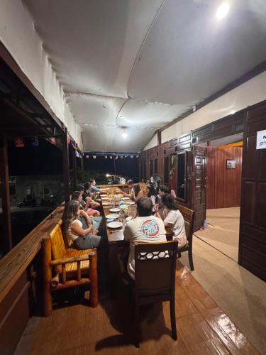 a group of people sitting at tables in a restaurant at NASRUL HOUSE HOMESTAY FOR BACKPACKERS in Maros