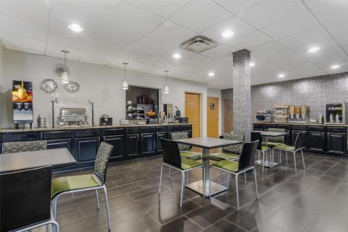 a restaurant with tables and chairs and a counter at Best Western Commerce Inn in Commerce