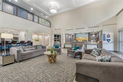 a large living room with couches and a table at Best Western Plus McPherson in McPherson