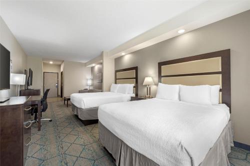 a hotel room with two beds and a desk at Best Western Plus McPherson in McPherson