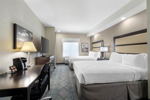a hotel room with two beds and a desk at Best Western Plus McPherson in McPherson