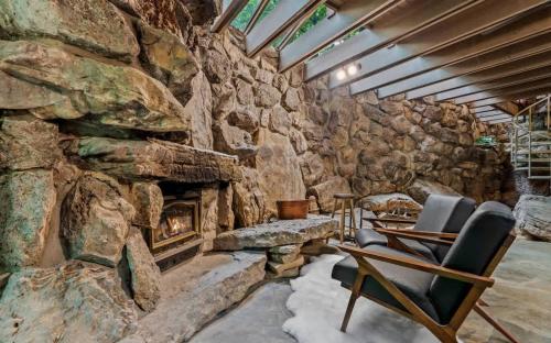 Zimmer mit einer Steinmauer und einem Kamin in der Unterkunft Stoneflower Cottage in Heber Springs