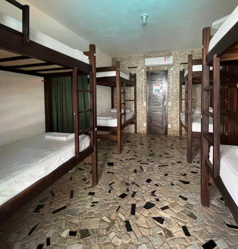 a room with three bunk beds in a building at No Worries Pipa in Pipa